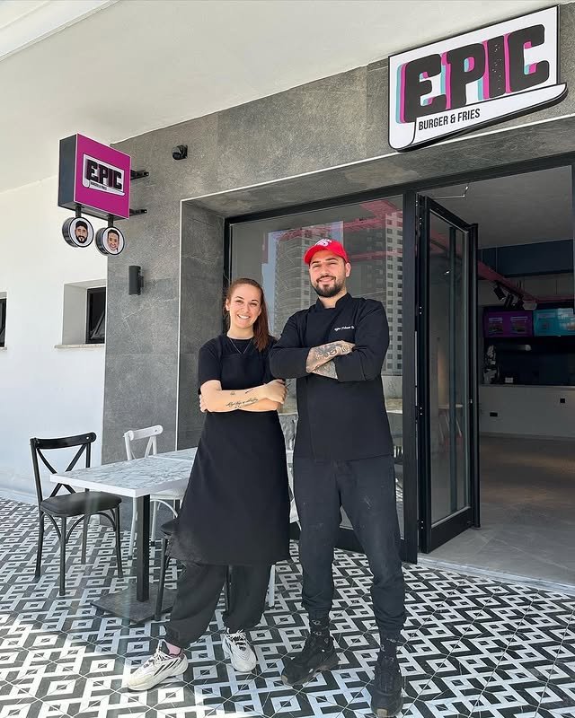 Tanya ve Uğur Epic Burger logosunun önünde